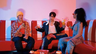 Takım çalışmalarını kutlamak için neon lambalı çok kültürlü bir arkadaş bardak tokuşturuyor. Renkli meyve suyu ve tokuşturarak şık modaya sahip profesyonel çeşitli insanlar. Mutluluk.