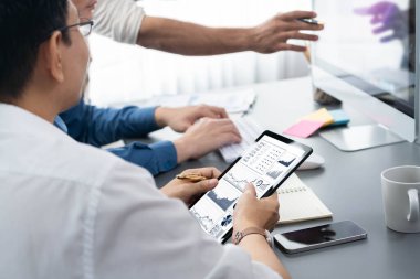 Veri analistleri ofis çalışanlarından oluşan bir ekip, tablet kullanarak finansal, trend ve pazarlama verilerini analiz etmek için iş istihbaratı BI gösterge paneli üzerinde işbirliği yapmaktadır. BI teknolojisi ve veri analizi kavramı. Tedbirli