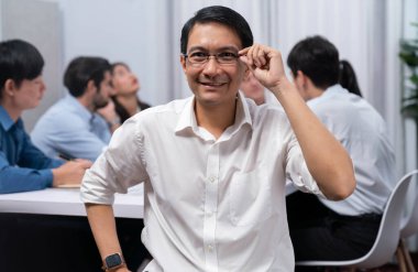 Ofiste çalışan iş arkadaşı ve iş adamlarının geçmişine sahip özgüven ve mutlu gülümseyen iş adamı portresi. Ofis çalışanı takım çalışması ve pozitif iş yeri konsepti. Tedbirli