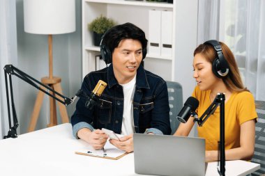 Gülümseyen radyo etkili sunucular, kulaklık takıp sosyal medyayı canlı yayında dinleyicilere telefon ve dizüstü bilgisayarla canlı yayınlıyorlar. İnfobahn.