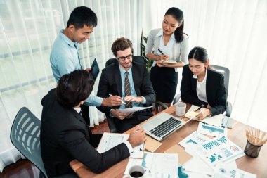 Ofis masasındaki finansal veri raporlarını analiz eden çeşitli bir grup iş analisti. Stratejik pazarlama planlaması için iş istihbarat analizine göre grafikler ve grafikler.