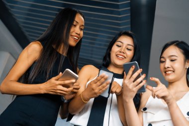 Üç kadın arkadaş ellerinde cep telefonuyla sohbet ediyorlar. Sosyal medya, dedikodu haberleri ve online alışveriş kavramı. uds