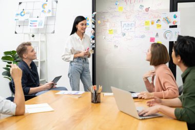 Genç ve güzel lider pazarlama stratejisini sunarken, uzman yatırımcı ve proje yöneticisi de yeni başlayan iş toplantısında iş performansını analiz etmeye çalışıyor. Çok ırklı bir grup. Tertemiz..