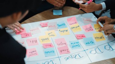 İş adamlarının işyerinde iş akışını yönetmek için sıkı yönetim kurulu kurması. Çeşitli pazarlama ekibi bir sınır çiziyor ve Kanban üzerinde çalışmak için renkli notlar kullanıyor. Kapatın. Müdürlük.