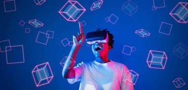 Geometrik şekillerde süzülürken mavi arka planda duran zeki çocuk. Afrikalı bir adam oyun oynuyor, VR gözlük takıyor ve sıradan bir gömlek giyiyor. Gelişmiş gerçeklik teknolojisi yenilik kavramı. Yaratıcılık.