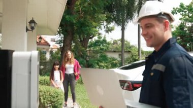 Evde EV şarj istasyonu kurulumu üzerinde çalışan nitelikli teknisyen, EV için dizüstü bilgisayarla şarj sisteminde sorun çıkarma ve yapılandırma ayarları yapıyor. Titiz