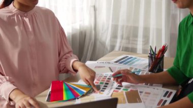 Grafik tasarımı için renk seçimi yapan ve beyin fırtınası yapan iki tasarımcının yavaş çekim çekimi ya da tasarım bürosunda kromatik danışmanlık hizmeti isteyen bir müşteri. Değiştirilmiş