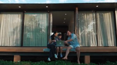 Şirin baba, anne ve kızı birlikte evin bahçesinde oturuyorlar. Ebeveynler, çevre farkındalığıyla ilgili genç nesli iletişim kurmak için açık hava aktivitelerini kullanırlar. Uyumsuzluk.