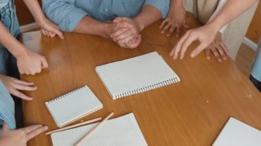 Kafkas öğretmeni ve çeşitli çocuklar başarılı bir projeyi kutlamak için el ele tutuşurken kağıt masaya saçıldı. Aşkı, şirketi, takım çalışmasını, birlikteliği ve birliği temsil et. Öğretim