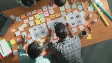 İş dünyasının zaman atlaması renkli notlarla toplantı masasına grafik logosu koydu ve fikri açıklarken tasarım yapmaya başladı. Proje yöneticisi grup halinde yürürken konsept sanatı anlatıyor. Sempozyum.