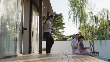 Şirin baba, anne ve kızı birlikte evin bahçesinde oturuyorlar. Ebeveynler, çevre farkındalığıyla ilgili genç nesli iletişim kurmak için açık hava aktivitelerini kullanırlar. Uyumsuzluk.
