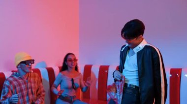 Asyalı bir adam pop müzikle dans ederken, çok kültürlü bir arkadaş evde ışık altında oturuyor. Çekici bir sokak dansçısı kameraya bakarken hip hop müzik dinliyor. Mutluluk.