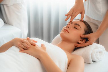 Kafkasyalı kadın stres önleyici kafa masajından ve lüks tatil beldesi ya da otel spa salonundaki modern ışık ortamında yüz güzelliği eğlencelerini şımartmaktan hoşlanıyor. Sessiz.
