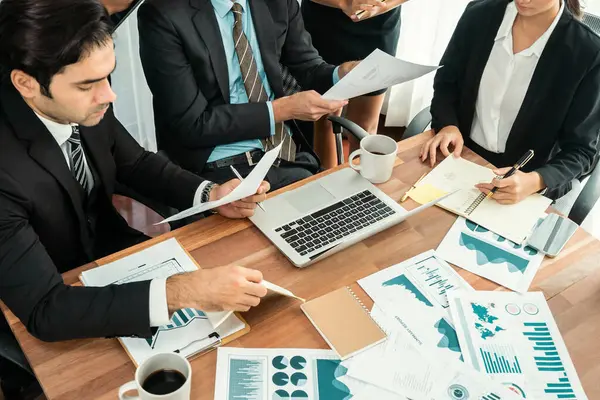 Ofis masasındaki finansal veri raporlarını analiz eden çeşitli bir grup iş analisti. Stratejik pazarlama planlaması için iş istihbarat analizine göre grafikler ve grafikler.