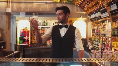 İçki tezgahındaki müşteriye içki servisi için buzlu akıllı barmen soğutma bardağı. Cazibeli profesyonelliğiyle hoş geldin içeceği. Kulüpte ilk izlenimi veren harika bir karşılama tahmini. Vinosity.