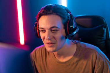 Kazanmak için çevrimiçi oyun oynayan akıllı flama makinesinin sunucu kanalı, neon ışıklı odada seçilen takım yarışması için izleyicilerle birlikte canlı yayında canlı yayında kulaklık takıyor. Bireysel.