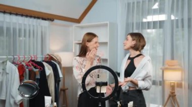 İki kadın nüfuzlu partner sosyal medya veya blog için canlı yayın yapan video klip inceleme derisi çekiyorlar. Kozmetik stüdyosu ışıklandırması olan genç bir kız pazarlama oturumu çevrimiçi yayın yapıyor.