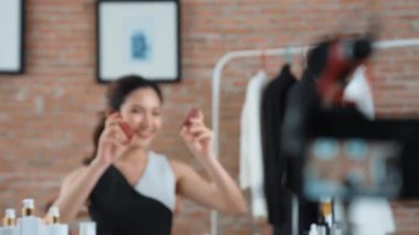 Kadın nüfuzlu kişi canlı yayın yapan video görüntülerini sosyal medya ya da blog üzerinden gözden geçiriyor. Kozmetik stüdyosu ışıklandırmalı mutlu genç kız çevrimiçi pazarlama oturumu yayını için..