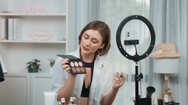 Kadın Etkilenen Vlog video görüntülerini canlı yayınlıyor Makyaj primi sosyal medya veya blog. Kozmetik stüdyosu ışıklandırmalı mutlu genç kız çevrimiçi pazarlama oturumu yayını için..