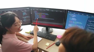 Yavaş çekim arkası yazılım geliştirici mühendisi bilgisayar programlama için birlikte çalışarak hata ayıklama kodunu çözüyor, ofiste monitörde karmaşık algoritmaları çözüyor. Filizlenen