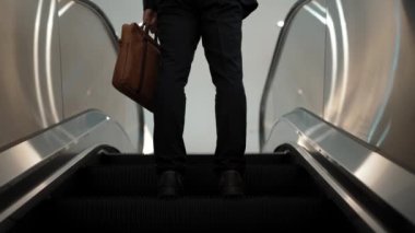 Yürüyen merdivenlerde duran zeki profesyonel iş adamının bacağı. Yetenekli proje yöneticisi terfi alıyor, yeteneğini arttırıyor, yükseltiyor, yeni bir pozisyon alıyor. Merkez. Bacağa odaklan. Sevinçli..