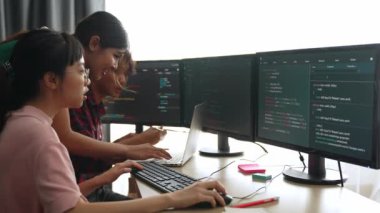 Yavaş çekim arkası yazılım geliştirici mühendisi bilgisayar programlama için birlikte çalışarak hata ayıklama kodunu çözüyor, ofiste monitörde karmaşık algoritmaları çözüyor. Filizlenen