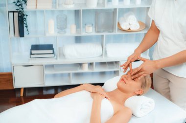 Kafkasyalı kadın stres önleyici kafa masajından ve lüks tatil beldesi ya da otel spa salonundaki modern ışık ortamında yüz güzelliği eğlencelerini şımartmaktan hoşlanıyor. Sessiz.