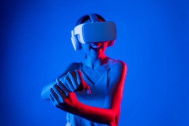 Akıllı kadın, metaevreni, gelecekteki siber uzay topluluğunu bağlayan VR kulaklık takıyor. Sanal lazer kılıcını kontrol eden zarif bir kadın ciddi ciddi dövüş oyunları oynuyor. Halüsinasyon.