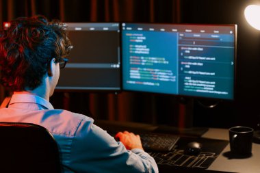 Uygulama pc ekranları ile çevrili çevrimiçi yazılım geliştirme bilgilerini yoğunlaştıran IT geliştiricisi, neon modern ofis evindeki web sitesinde yazılım için program yaratıyor. Toplayıcı.