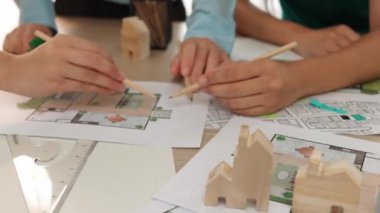 Mimari döküman, ölçüm araçları ve ahşap blokların modern ofiste etrafa saçıldığı masa üzerine planlar yapma konusunda akıllı mimar ve güvenlik mühendisi tartışması. - Yakın çekim. Tanımlama.