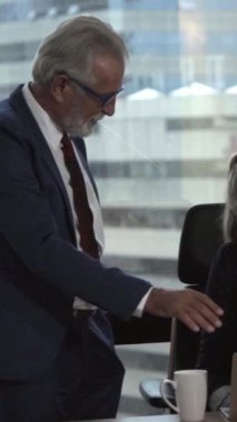 Üst düzey yönetici modern ofisteki genç kadın çalışana tavsiyelerde bulunuyor. Liderlik ve eğitim kavramı.