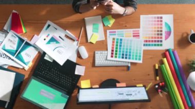 Top down aerial view of skilled interior design graphic talking to manager by using phone. Project manager working while using telephone and listen to team and discuss building design idea. Symposium.