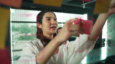 Genç kendine güvenen iş kadını projeyi uzman yatırımcıya sundu. Profesyonel proje yöneticisi başlangıç projesini açıklamak için yapışkan notlar kullanır, beyin fırtınası fikirlerini yatırımcıya paylaşır. Yönlendirici.