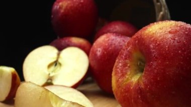 Makrografi, taze elma dilimleri çarpıcı bir siyah arka plana karşı bir kesme tahtasına yerleştirilmiştir. Her yakın çekim elmaların canlı dokusunu ve canlı renklerini yakalar. Geliştirilebilir.