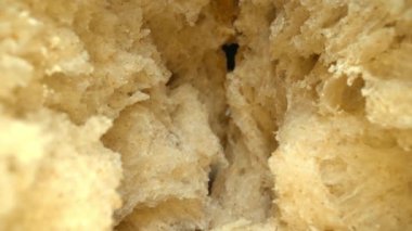 Koyu arkaplanda taze ekmek parçacıkları var. Tahta tepsiye yerleştirilmiş ekmeğin makro fotoğrafçılığı. Kamera hareketini yakınlaştır. Gurme ve fırın konsepti. Poster için tasarım, yemek blogu. Pabulum.