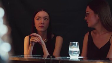 Güzel bir kadının portresi, lüks bir tezgah içecek barında arkadaşlarıyla sohbet edip, dilimlenmiş portakallı gazoz içerken. Kulüpte sosyetenin özünü yakalamak. Vinosity.