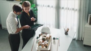 Profesyonel mimar mühendis oturmuş müdüre ev planını açıklarken. Toplantı odasında inşaat hakkında konuşurken akıllı tasarımcının planının havadan görünüşü. Hizalama.