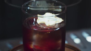 Barmenin açılışı eski usul cam kokteyl viskisiyle kaplıydı. Üstünde kaya buzlu, dilimlenmiş elma vardı. Alkol serinletici vitrin odaklı özel içecek reklamı yapıyordu. Vinosity.