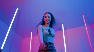 Latin dansçıların kameraya bakıp şehrin pop müziğiyle dans ettiği düşük açılı kamera. Profesyonel çekici hipster, mor veya neon ışıklı hip hop şarkısına geçiyor. Şık bir kumaş. Mutluluk.