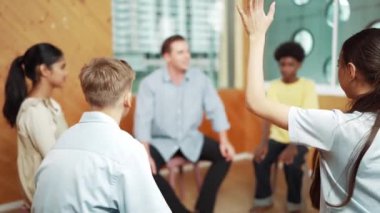 Grup terapisi sırasında soru sormak için elini kaldıran akıllı kız. Lise öğrencisi, grup toplantıları arasında soru sormak, oy vermek, gönüllü olmak, soru sormak ve cevaplamak için el kaldırdı.