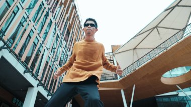 İspanyol dansçı hip hop tarzında dans ederken kameraya bakıyor. Genç ve çekici bir hippi müzik eşliğinde dans ediyor. Break dansçının hareket çekimi B-boy dansını gerçekleştirmek Açık hava sporu 2024. Hiphop.