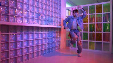 Gece kulübünde kameraya bakarken güneş gözlüklü Asyalı dansçı serbest dans ediyor. Mutlu sokak dansçısı dans ediyor ve renkli parlak neon ışığı ya da yol gösteren ışıkla ayak seslerini gösteriyor. Mutluluk.