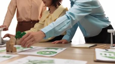 Şirketin gelecekteki EG 'si için danışmanlık yapıyorum. Temiz enerji ile temsil edilen yel değirmeni modeli, sembolize edilmiş eko ev ve masada yeşil güç grafiği kullanımı serpintisi. Tanımlama.