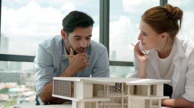 Yetenekli mimar mühendis takımı ev modeli inşaatı hakkında konuşuyor. Başarılı iç tasarım beyin fırtınası, paylaşım, mimari tasarım. Yaratıcı tasarım. İzleme