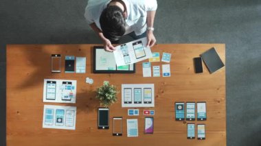 İş adamının toplantı odasında Ux Ui tasarımına bakması ve onu seçmesi. Yetenekli geliştirici yaratıcı iş yerinde cep telefonu arayüzü ya da yazılım uygulaması tasarlıyor ve planlıyor. Cemaat.