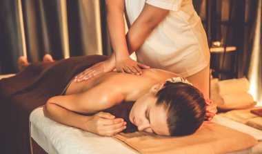 Beyaz kadın müşteri stres önleyici spa masajının keyfini çıkarıyor ve lüks otel ya da otelde sıcak mum ışığında güzellik teniyle eğleniyor. Sessiz.