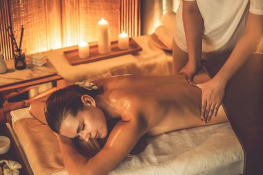 Beyaz kadın müşteri stres önleyici spa masajının keyfini çıkarıyor ve lüks otel ya da otelde sıcak mum ışığında güzellik teniyle eğleniyor. Sessiz.