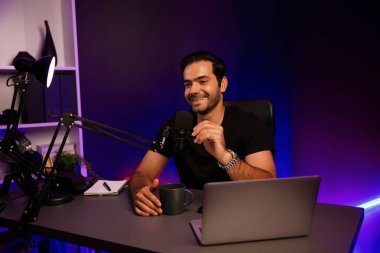 Yayıncı, fanclub dinleyicisiyle mikrofon kullanarak konuşuyor. Mor neon ışıklı modern stüdyoda yaratıcı olumlu düşünce konseptiyle canlı yayında finansal sorunları tartışıyor. Tahmin et..