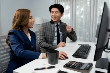 Güler yüzlü Asyalı bir adam pazarlama projesini tartışırken ara verildiğinde takım elbiseli bir kadınla birlikte yaratıcı ekip çalışması projesinde çalışıyor. İnfobahn.