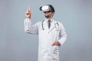 Kafkasyalı doktor metaevreni bağlamak için VR gözlük kullanırken tıbbi verilere bakıyor. Laboratuvar önlüğü ve görsel gerçeklik giyerken bir şeyi tutup işaret eden yetenekli bir doktor. Sapma.